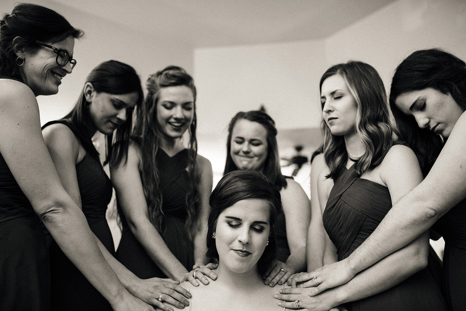 bridesmaids praying for bride before her wedding