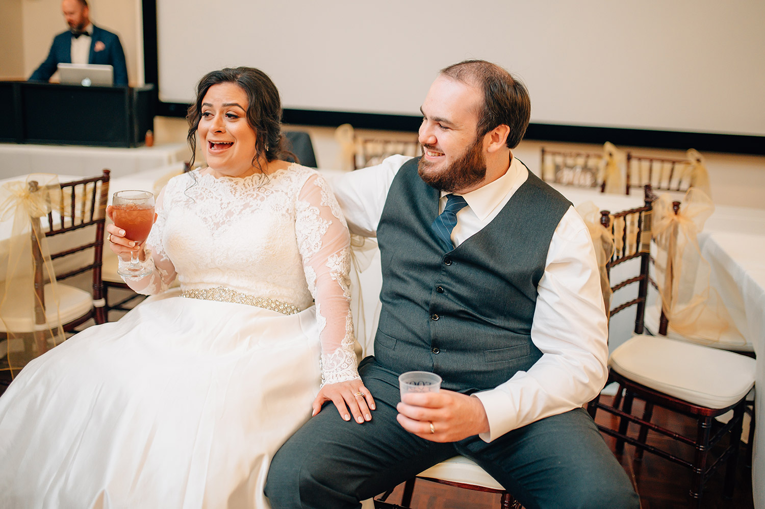 bride and groom react to toasts at their wedding reception